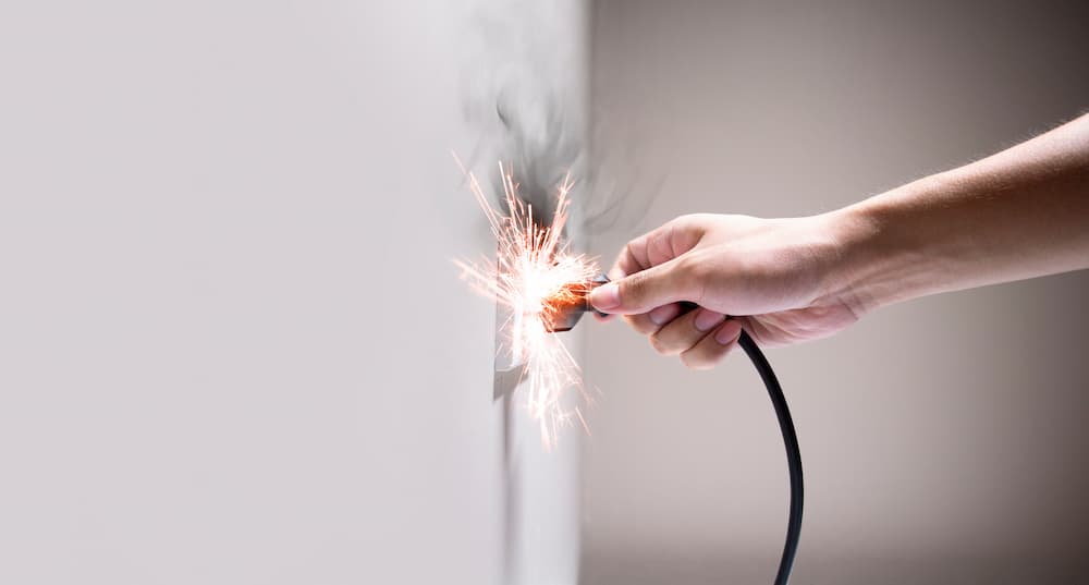 A plug releasing a large electric spark resulting in electric shock